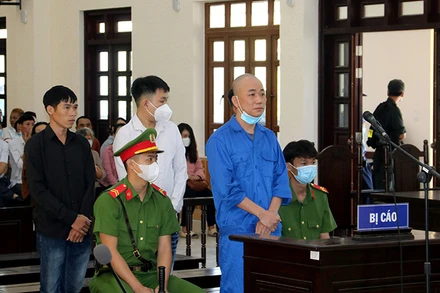 Bị cáo Phạm Văn Nam (đứng trước) và ba bị cáo: Trần Quốc Phong, Nguyễn Thiện Khiêm và Võ Lam Trường (đứng hàng sau) tại phiên tòa.