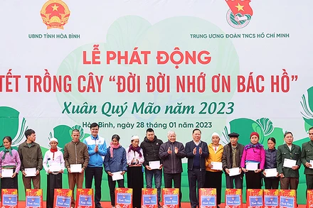 Các đồng chí Đỗ Văn Chiến, Nguyễn Phi Long, Bùi Quang Huy (lần lượt thứ 9, 8 và 13 từ phải sang) trao quà tặng đại diện các gia đình chính sách, hộ dân có hoàn cảnh khó khăn tại buổi lễ.