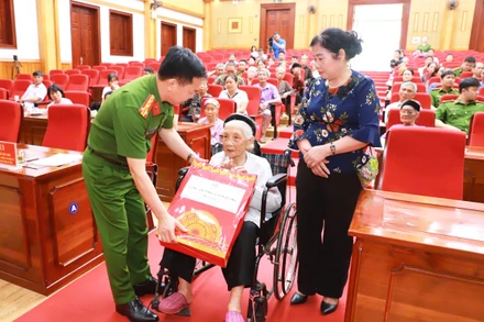 Đại tá Đỗ Tiến Thùy, Phó Giám đốc Công an tỉnh Tuyên Quang tặng quà Mẹ Việt Nam Anh hùng, mẹ liệt sĩ tham gia lấy mẫu.