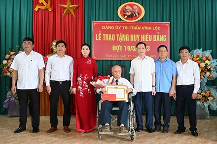 Đồng chí Lê Thị Kim Dung, Phó Bí thư Thường trực Tỉnh ủy, Chủ tịch Hội đồng nhân dân tỉnh Tuyên Quang trao Huy hiệu 75 năm tuổi Đảng và tặng hoa chúc mừng đảng viên Ma Phúc Tiến, Đảng bộ thị trấn Vĩnh Lộc, huyện Chiêm Hóa.