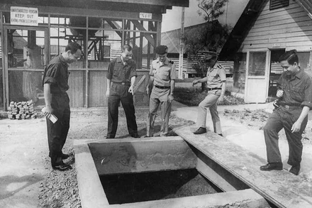 Thiếu tướng Hoàng Anh Tuấn, Trưởng đoàn đại biểu quân sự Chính phủ Cách mạng lâm thời Cộng hòa miền nam Việt Nam (thứ 2 từ trái sang), đang chỉ cái giếng mà phía địch vu cáo là hầm chiến đấu do ta đào trong Trại Davis (tháng 4/1975). (Ảnh: ĐINH QUỐC KỲ)