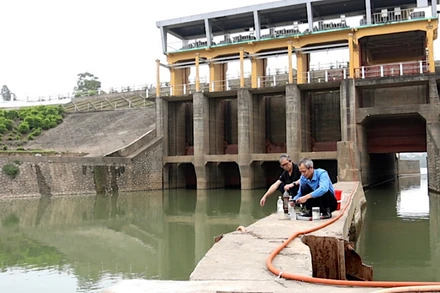 Cán bộ Viện nước Tưới tiêu và Môi trường lấy mẫu kiểm tra chất lượng nước tại trạm bơm dã chiến Xuân Quan.