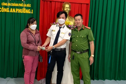 Anh Huân trao trả số tiền 100 triệu đồng cho chị N trước sự chứng kiến của Công an phường 1.