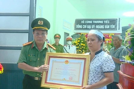 Thừa ủy quyền của Chủ tịch nước, đại tá Nguyễn Văn Ngàn trao Huân chương Bảo vệ Tổ quốc hạng Ba cho gia đình Đại úy Hoàng Văn Yên.