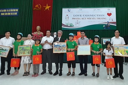 Các nhà tài trợ tặng quà, mũ bảo hiểm cho trẻ em đặc biệt khó khăn.