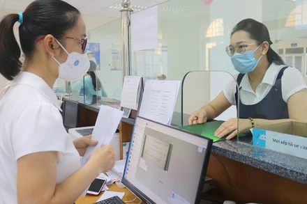 Cán bộ Bảo hiểm xã hội tỉnh hướng dẫn chi trả chế độ cho người lao động. 