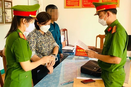 Công an tống đạt quyết định khởi tố bị can, bắt tạm giam Trần Thị Hồng. (Ảnh Công an cung cấp)