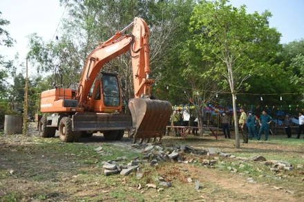 Lực lượng chức năng dùng xe múc tiến hành cưỡng chế công trình xây trái phép khu vực lòng hồ Trị An.