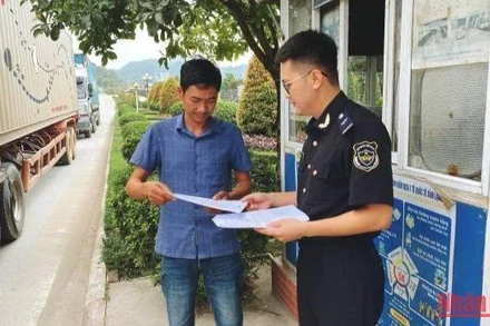 Cán bộ Chi cục Hải quan cửa khẩu quốc tế Hữu Nghị phát tờ rơi hướng dẫn Nền tảng cửa khẩu số cho lái xe tại cửa khẩu quốc tế Hữu Nghị. 