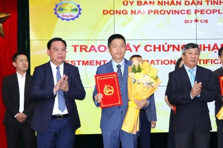 Phó Bí thư Thường trực Tỉnh ủy Hồ Thanh Sơn và Chủ tịch Ủy ban nhân dân tỉnh Đồng Nai Võ Tấn Đức trao giấy chứng nhận đăng ký đầu tư và tặng hoa chúc mừng cho doanh nghiệp.