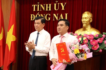 Bí thư Tỉnh ủy Đồng Nai Nguyễn Hồng Lĩnh trao quyết định và tặng hoa chúc mừng đồng chí Hồ Văn Nam.