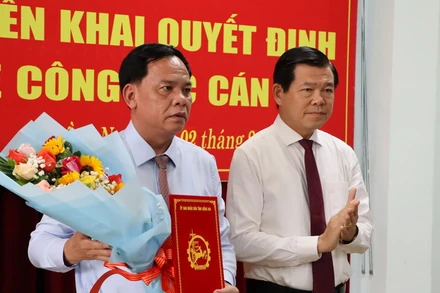 Bí thư Tỉnh ủy Đồng Nai Nguyễn Hồng Lĩnh trao quyết định và tặng hoa chúc mừng đồng chí Võ Tấn Đức.