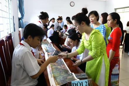 Học sinh, giáo viên Trường trung học cơ sở Phước Tân 3 hào hứng trải nghiệm tranh panorama Chiến dịch Điện Biên Phủ của Báo Nhân Dân.