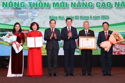 Phó Thủ tướng Trần Lưu Quang và Bí thư Tỉnh ủy Đồng Nai Nguyễn Hồng Lĩnh trao danh hiệu huyện nông thôn mới nâng cao, tặng hoa chúc mừng lãnh đạo huyện Xuân Lộc.