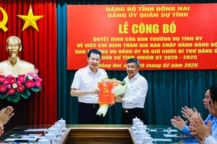 Phó Bí thư Thường trực Tỉnh ủy Đồng Nai trao quyết định và tặng hoa chúc mừng đồng chí Vũ Hồng Văn, Bí thư Tỉnh ủy, Bí thư Đảng ủy Quân sự tỉnh.