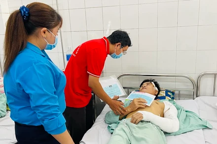 Đại diện Hội Chữ thập đỏ tỉnh Đồng Nai trao số tiền hỗ trợ công nhân bị thương.