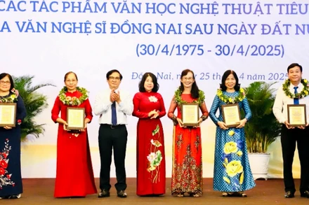 Phó Chủ tịch HĐND tỉnh Đồng Nai Hoàng Thị Bích Hằng và Phó Chủ tịch UBND tỉnh Nguyễn Sơn Hùng trao biểu trưng tôn vinh cho đại diện gia đình các văn nghệ sĩ.