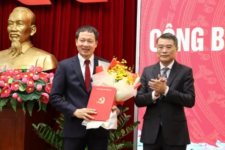 Đồng chí Lê Minh Hưng trao quyết định và tặng hoa chúc mừng đồng chí Vũ Hồng Văn.