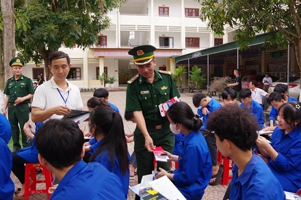 Ban tổ chức phát tờ rơi tuyên truyền cho học sinh Con Cuông.