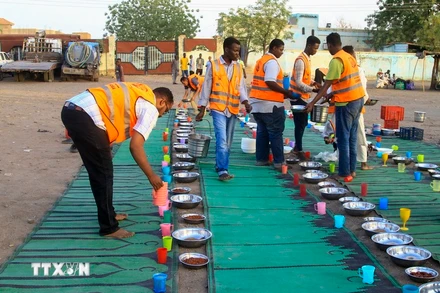 Tình nguyện viên chia suất ăn cứu trợ cho người tị nạn. (Ảnh: AFP/TTXVN)