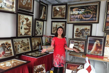 Chị Nguyễn Thị Vân, xã Đông Xuân, huyện Sóc Sơn (Hà Nội) bên các tác phẩm tranh gạo.