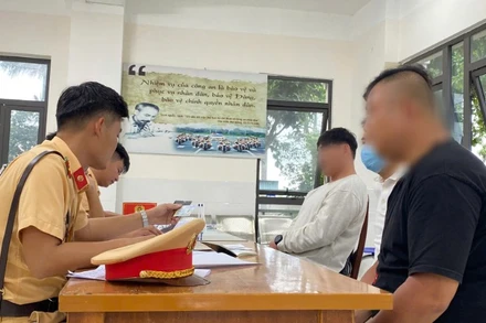 Cán bộ Phòng Cảnh sát Giao thông Công an tỉnh Quảng Nam làm việc với 2 người nước ngoài vi phạm trật tự an toàn giao thông.