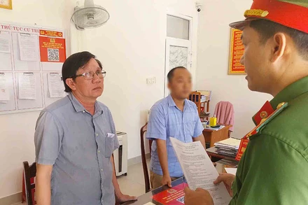 Công an đọc quyết định khởi tố và bắt tạm giam ông Võ Xuân Hiếu (người đeo kính) về tội lừa đảo chiếm đoạt tài sản.