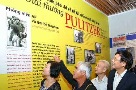 Kim Phúc (bên trái) và Nick Út (thứ hai, trái sang) xem lại những bức ảnh lịch sử. Ảnh: SƠN HẢI