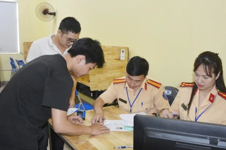 Cán bộ Phòng Cảnh sát Giao thông hướng dẫn học viên thủ tục thi.