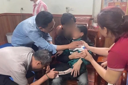 Cháu bé trong vòng tay gia đình sau cuộc giải cứu.