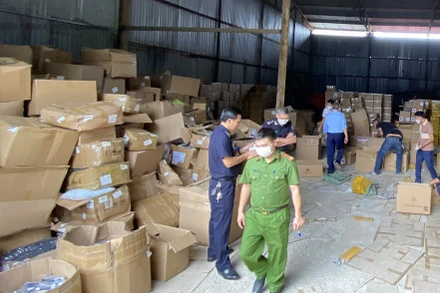 Các lực lượng chức năng kiểm tra kho hàng. ( Ảnh: CAND)