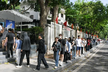 Hàng dài người dân, du khách tại khu vực phố đi bộ Hồ Hoàn Kiếm đợi nhận phụ san đặc biệt kỷ niệm 135 năm Ngày sinh Chủ tịch Hồ Chí Minh.