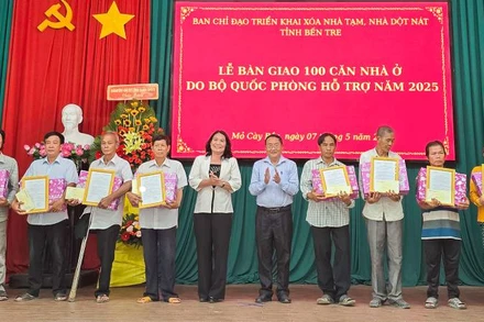 Lãnh đạo tỉnh Bến Tre trao quyết định bàn giao nhà, quà cho các hộ dân tại buổi lễ. (Ảnh: HOÀNG TRUNG)