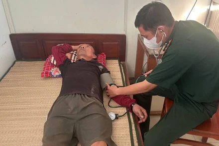 Bác sĩ Đồn Biên phòng Hàm Luông kiểm tra sức khỏe thuyền viên. (Ảnh: HOÀNG TRUNG)