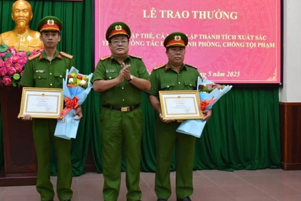 Đại tá Võ Công Bình, Phó Giám đốc Công an tỉnh Bến Tre trao giấy khen cho 2 cá nhân có thành tích xuất sắc trong triệt xóa tụ điểm ma túy. (Ảnh: HOÀNG TRUNG)