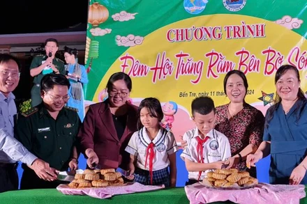 Đại biểu tham dự Chương trình cùng các cháu thiếu nhi thực hiện nghi thức Phá cỗ Trung thu. (Ảnh: MINH NGỌC)