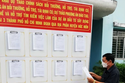 Người dân xã Xuân Thới Thượng, huyện Hóc Môn, Thành phố Hồ Chí Minh xem thông tin niêm yết về chính sách đền bù dự án Vành đai 3.