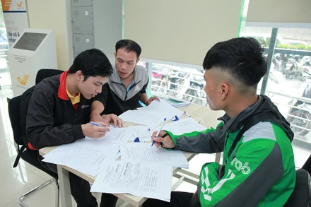 Nhân viên Bưu điện hướng dẫn khách hàng làm thủ tục đăng ký cấp phiếu lý lịch tư pháp tại Bưu cục Thăng Long.