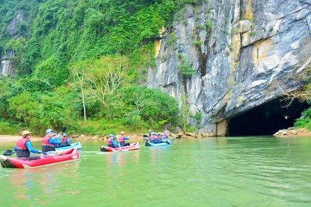 Du khách chèo kayak khám phá động Phong Nha. (Ảnh: Báo Nhân Dân)