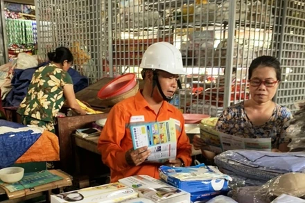 Nhân viên Điện lực Thừa Thiên Huế tuyên truyền về sử dụng điện an toàn, tiết kiệm cho tiểu thương chợ Đông Ba.