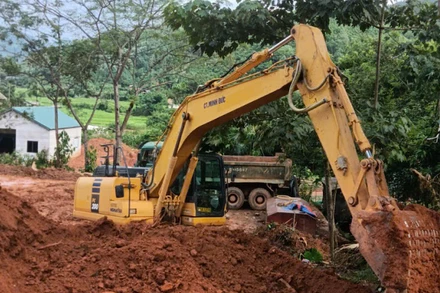 Phương tiện xe máy san lấp mặt bằng chuẩn bị khởi công dự án Khu tái định cư Làng Nủ.