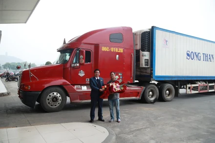 Trưởng Ban quản lý Khu kinh tế Lào Cai Vương Trinh Quốc tặng hoa lái xe chở chuyến hàng đầu tiên xuất khẩu “xông đất” Cửa khẩu đường bộ Kim Thành trong sáng ngày mùng 1 Tết. (Ảnh: Ngọc Bằng)