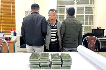 Đối tượng Vàng A Cháng cùng tang vật là 20 bánh heroin tại Cơ quan Công an tỉnh Lào Cai. (Ảnh: THANH TUẤN).