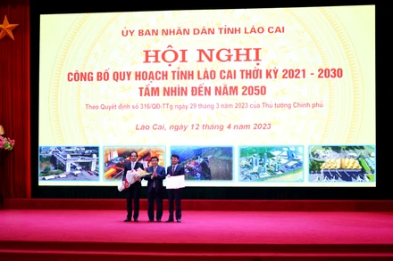 Thừa ủy quyền của Thủ tướng Chính phủ, Bộ trưởng Kế hoạch và Đầu tư Nguyễn Chí Dũng trao Quyết định phê duyệt Quy hoạch cho lãnh đạo tỉnh Lào Cai. (Ảnh: Quốc Hồng)