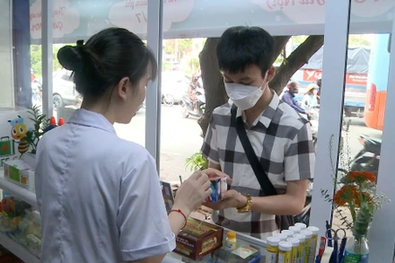 Nhân viên một cửa hàng thuốc tư vấn về thực phẩm chức năng cho người mua. (Ảnh: Thúy Quỳnh)