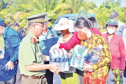 Cán bộ, chiến sĩ Phòng Công tác đảng và công tác chính trị (Công an tỉnh Cà Mau) vận chuyển, cung cấp nước sinh hoạt miễn phí cho người dân xã Khánh Bình Ðông, huyện Trần Văn Thời, tỉnh Cà Mau. 