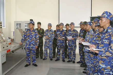 Học viên Trường cao đẳng Kỹ thuật Hải quân nghe giảng viên giới thiệu về trung tâm điều khiển pháo AK-630. 