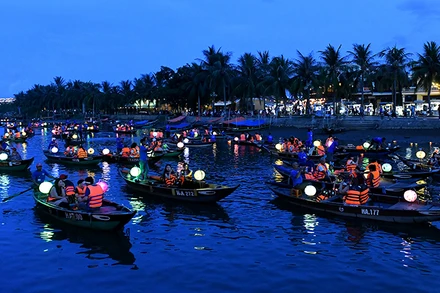 Du khách đi thuyền trên sông Hoài tham quan phố cổ Hội An vào ban đêm. (Ảnh ÐĂNG KHOA) 