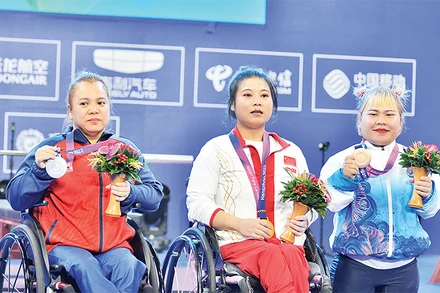 Lực sĩ Ðặng Thị Linh Phượng (ngoài cùng, bên trái) nhận HCB môn cử tạ. (Ảnh THÁI DƯƠNG)