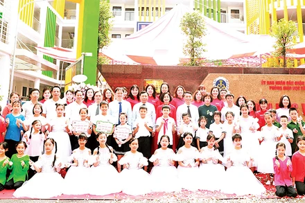 Thầy và trò Trường tiểu học Võ Thị Sáu (quận Hai Bà Trưng) trước ngôi trường mới. (Ảnh ÐÌNH HIỆP) 